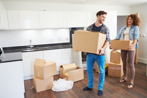 Local movers handling furniture and boxes on a residential street in Northolt