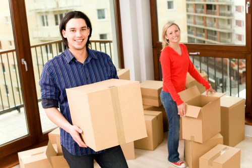 Removalists carrying furniture through a residential property in Northolt